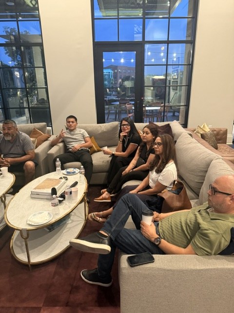 Guests seated together on the sectional at the first Bexar AI, September 30