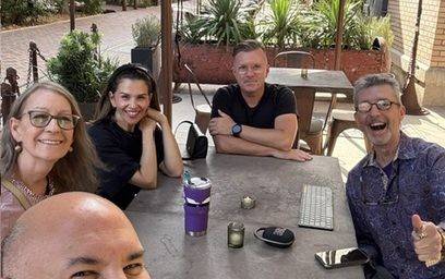 Guests around a table in a courtyard at a 5 Talents room